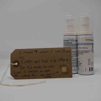 This image shows two Tostran testosterone 2% gel pump dispensers with a brown tag with handwritten text on it in front.