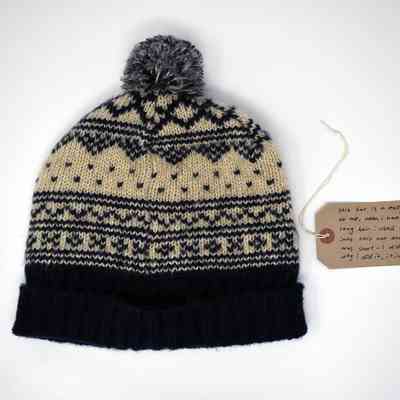 Knitted bobble hat with navy and white pattern.