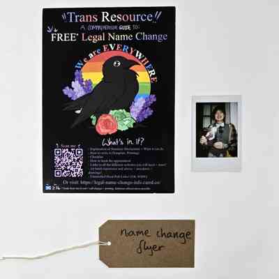 A "Trans Resource" flyer giving information and links about free legal name change. Also a polaroid and a brown, handwritten luggage tag.