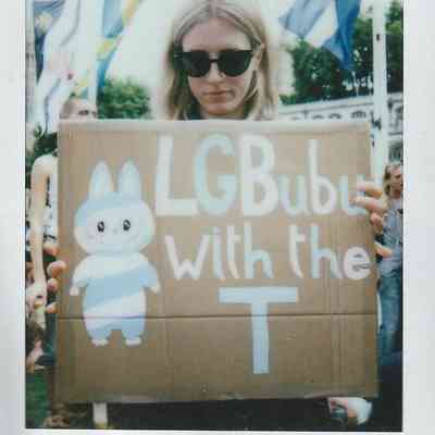 A person holds a sign which says "LGBUBU With The T".