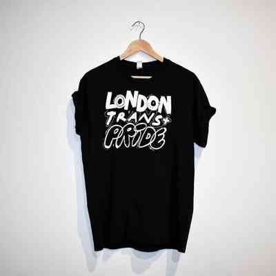 A black T-shirt with the text "LONDON TRANS+ PRIDE" in white on the front. On a wooden hanger.