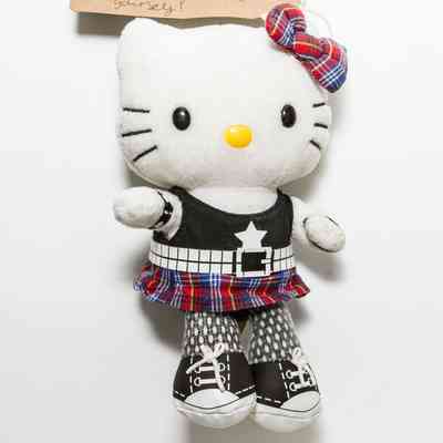 Soft Hello Kitty character toy wearing a plaid bow on one ear, black sleeveless shirt, studded belt, plaid skirt, leggings, wrist cuffs, and black and white shoes.