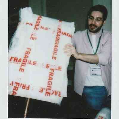 A man is carefully holding a package labeled "fragile".