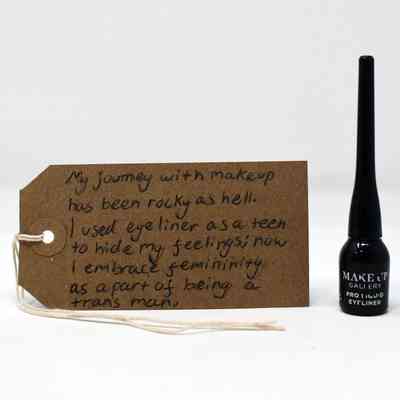 A black eyeliner and a brown luggage tag with writing on it.