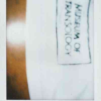 The image shows a blurred white tag labeled "Museum of Transology".