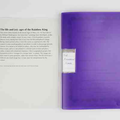 A purple document folder titled "The Rainbow King" rests beside a descriptive page.