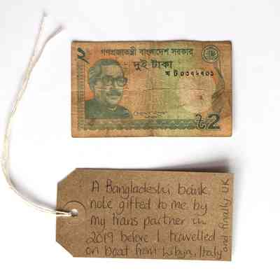 A Bangladeshi bank note with a brown luggage tag.