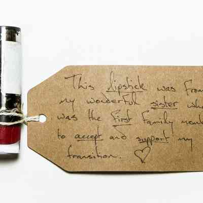 Black lipstick tube. Some of the black paint has been stripped away revealing silver underneath.