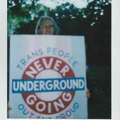A person holds a placard which says "Trans People Are Never Going Underground".