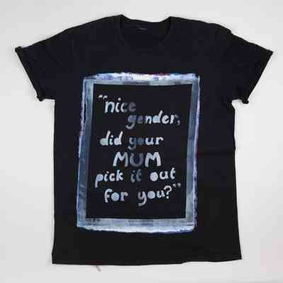 The black T-shirt has a printed quote framed with colorful paint, which says 'Nice Gender Did Your Mum Pick It Out For You?'
