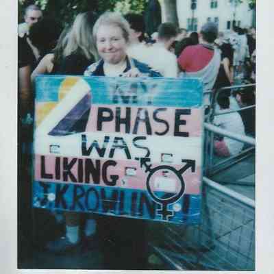 A person is holding a colourful protest saying "My Phase Was Liking J K Rowling".