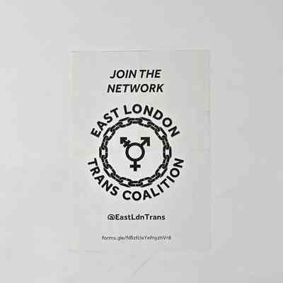 White leaflet with black lettering reading "JOIN THE NETWORK" and "EAST LONDON TRANS COALITION" in a circle around a chain with the gender diversity symbol in the middle. Underneath there is text reading "@East LdnTrans" and a link to a form