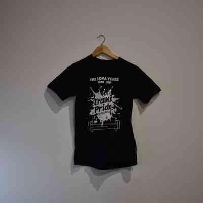 A black T-shirt on a hanger displays the text design for "The Sofa Years" and "Trans Pride".