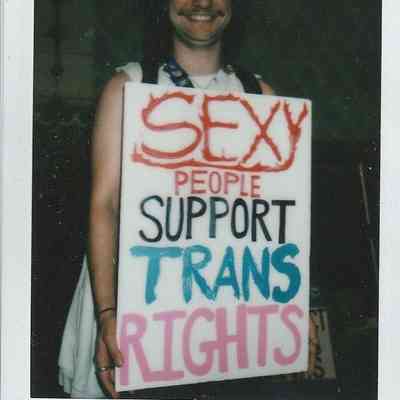 A person holds a sign that reads, "Sexy people support trans rights," expressing solidarity with the trans community.