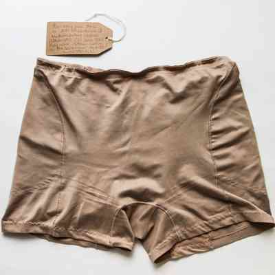 A pair of beige control pants with evidence of hand stitching in places.