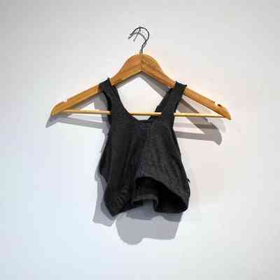 A handmade dark grey binder, made out of a pair of leggings, on a wooden hanger.