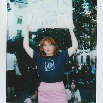 A person holds a sign reading “Trans rights are human rights” during a protest.