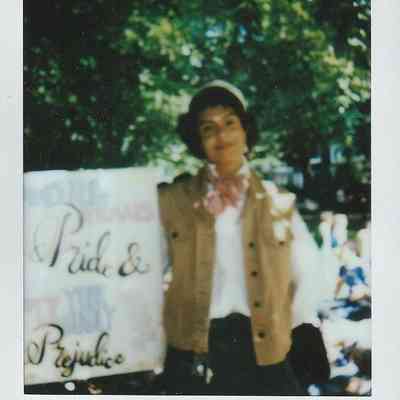 A person holds a placard which says "Pride & Prejudice".