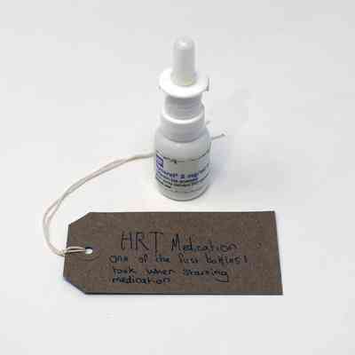 A labeled HRT medication bottle sits beside a handwritten note.