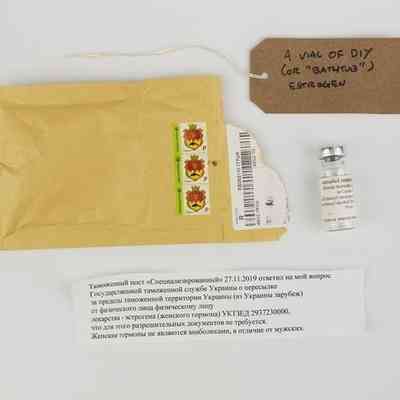 A vial of Estradiol with a padded envelope posted from Ukraine and a note in Cyrillic script. With a brown handwritten luggage tag.