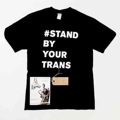 Black T-shirt with white block letters reading "# STAND BY YOUR TRANS"
