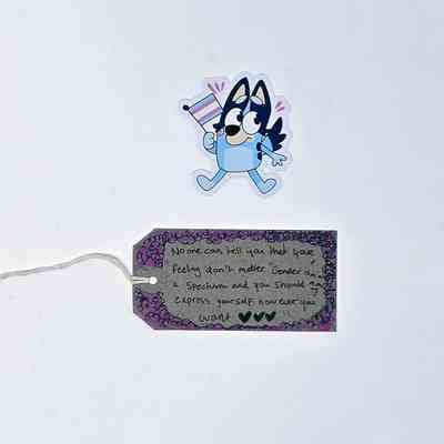 A cartoon character holds a flag above a tag with supportive, inclusive text and a decorative border.