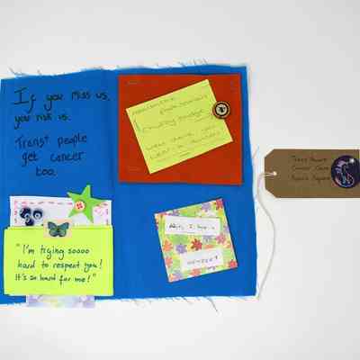 The image displays a fabric square with notes advocating for trans-inclusive cancer care awareness and respect.