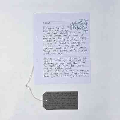 A letter writing about top surgery and a brown luggage tag.