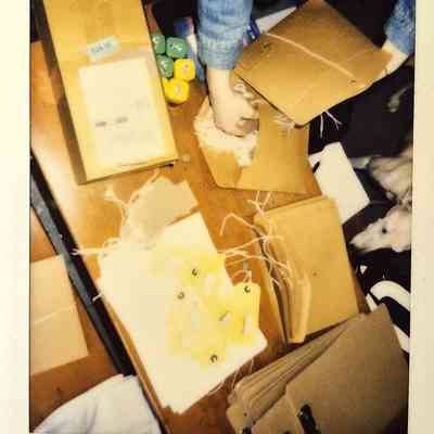 A table which is full and busy of peoples hands packing with labels.