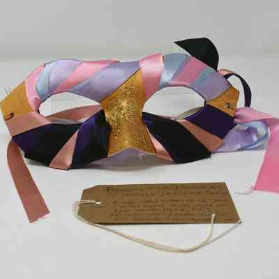 A mask which is wrapped in many different colours of fabric.