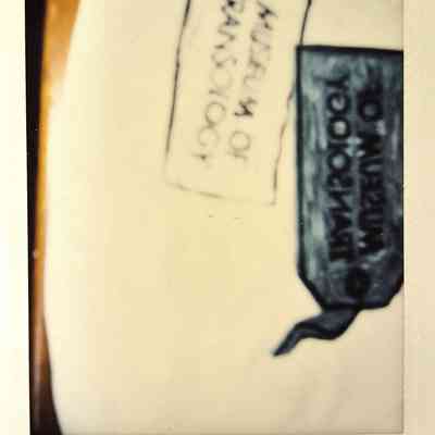 A blurry photograph where you can just about make out a few graphics of a tag which says 'Museum of Transology".