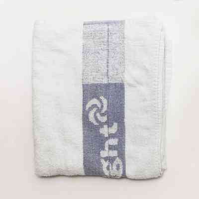 A neatly folded white towel features a distinctive blue stripe with a design and text.