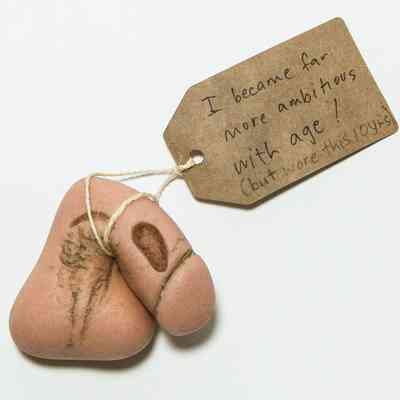 Prosthetic penis & testicles (packer) & tag; made of silicone, pink, moulded with grooves which have worn down & discoloured.