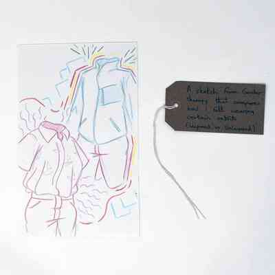 The image shows colorful sketches of outfits with a brown tag with writing on it.
