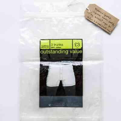 Plastic bag, packaging for M&S pack of 3 trunks. Rigid plastic, resealable bag, dark blue/green labelling. Surface covered in small dents. Several small circular magnets holding bag in folded in half position.