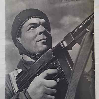 Back cover of magazine: A man armed with a gun looking upwards