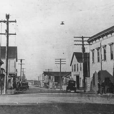 Antlers Tavern 22 X 34 (Torretta): Early in the 20th century, downtown Pinole had fourteen saloons; the Swenson and Lewis Saloon (left corner) and the Stats Hotel and Saloon (right corner) were two of them. This area, known as the Four Corners, was the hub of Pinole’s business and social life. After a brick building was built on the Stats Hotel site, Pontes and Barroca’s Central Grocery operated there for many years. Antlers Tavern now occupies the Swenson & Lewis site, and Tina’s Place occupies the Stats site. The entire west side of Tennent Avenue, including Forester’s Hall was destroyed in a massive blaze in 1908.The building with the cupola in the middle is today’s Antlers Tavern.