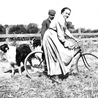 Ellerhorst daughter on bike (Mariotti): Photograph of Christina and C. H. Ellerhorst's daughter on bicycle with two dogs and gentleman beside her.
