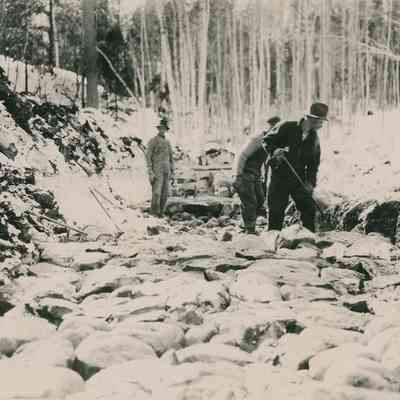 Men Laying Rock Bed in Winter