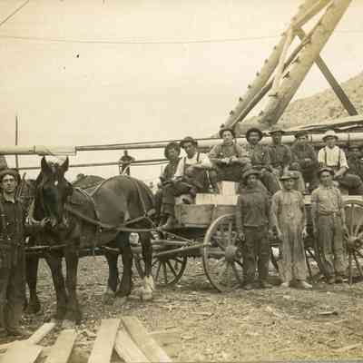 Workers on the back of a horsedrawn wagon
