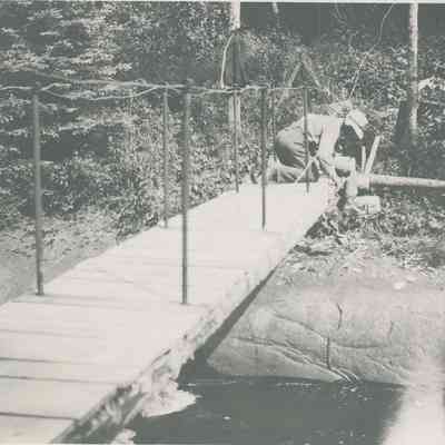 Men Kneeling on Foot Bridge