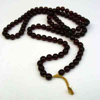 Necklace of red cherry amber prayer beads on yellow string