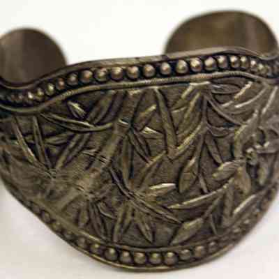 Silver repousse bracelet with bamboo and flower motifs