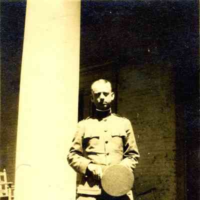 Photograph of a man in military uniform holding his hat
