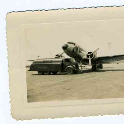 Photograph of an airplane next to a fuel truck