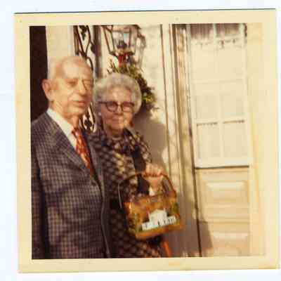 Photograph of a senior couple in front of a door to a house