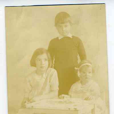 Studio photo postcard of three children - two girls and a boy