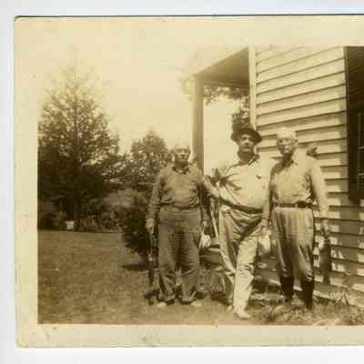 Photograph of three older men, two holding fish