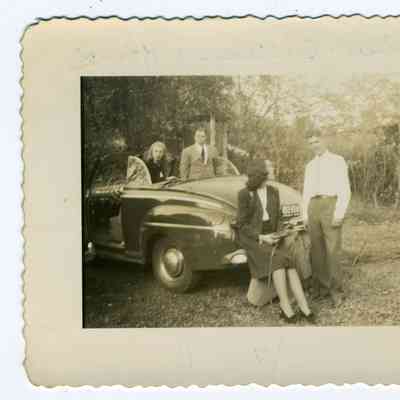 Photograph of two couples with convertible car