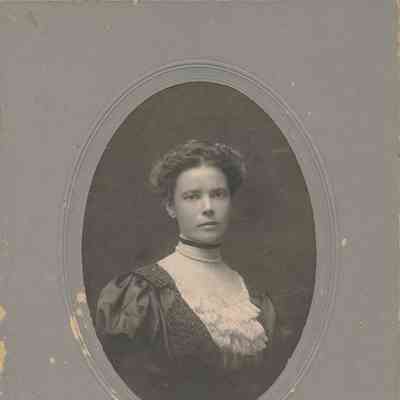 Studio photograph of a young woman in formal dress